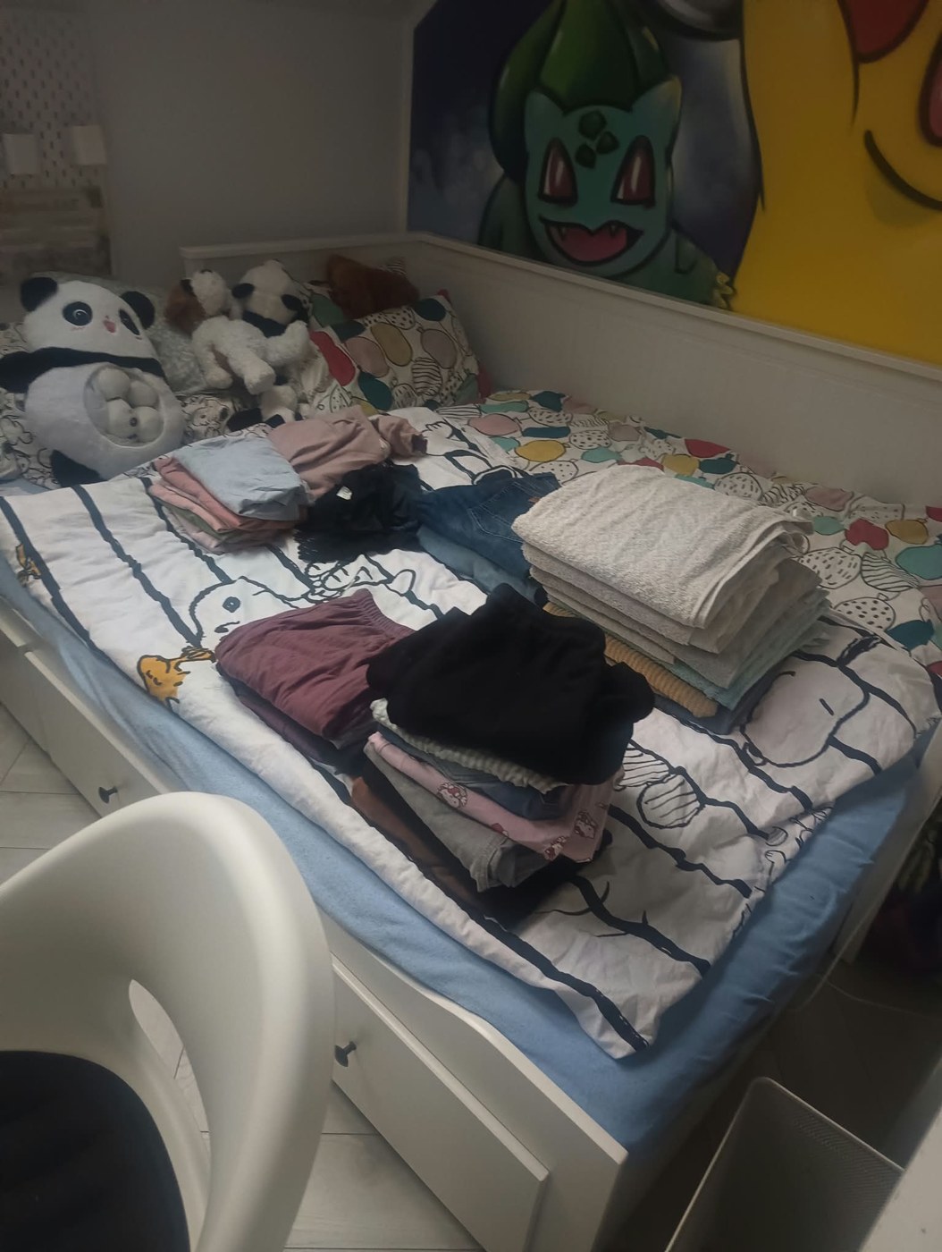 Ubrania starannie poskładane na łóżku po organizacji rzeczy