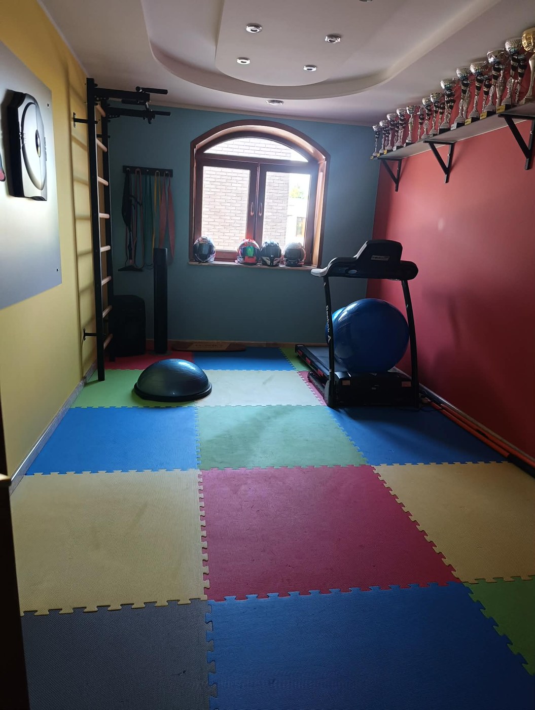 Sala treningowa z uporządkowanym sprzętem i czystą podłogą