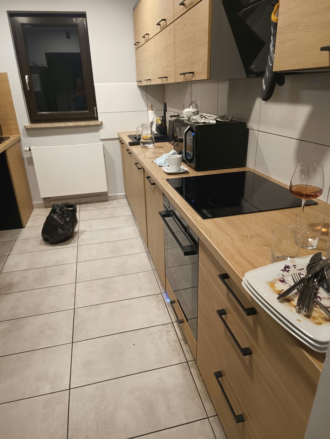 Kuchnia z naczyniami i workiem przed sprzątaniem
